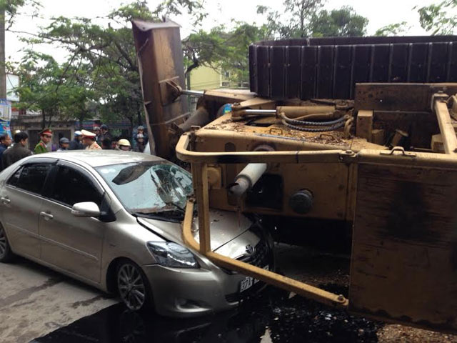 Máy ủi rơi từ xe đầu kéo đè bẹp ô tô, tài xế thoát chết