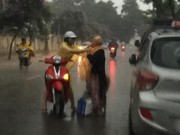 Tin tức trong ngày - Cô gái dừng xe giữa trời mưa lớn mặc áo mưa cho cụ già