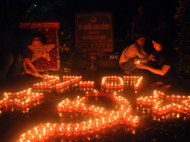 Ảnh: Hàng ngàn mộ liệt sỹ lung linh ánh nến dưới mưa