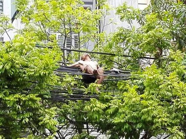 Tin tức trong ngày - Nam thanh niên cởi trần trèo lên đường dây điện nằm chơi