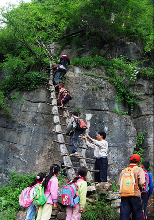 Giáo viên Li Guilin giúp các em học sinh trèo thang để lên ngôi trường nằm ở độ cao 2.800m so với mực nước biển.
