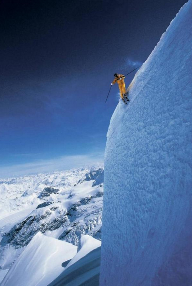 Một vận động viên trượt tuyết đang cố men theo một vách núi dựng đứng.
