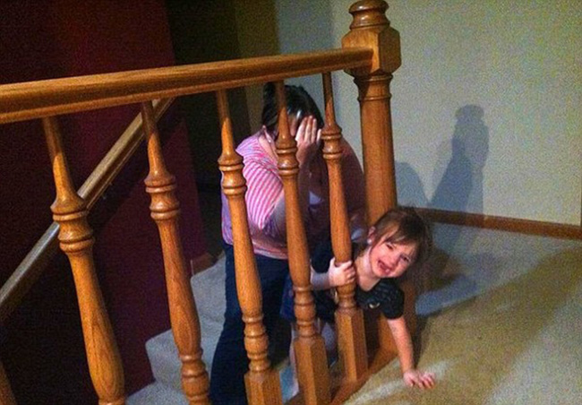 Cô bé hoảng sợ khi bị mắc kẹt ở lan can cầu thang

