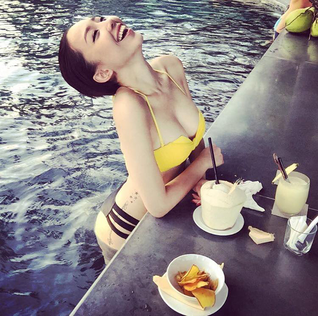 Tóc Tiên diện bikini khoe vòng 1 gợi cảm và nụ cười tỏa nắng bên bể bơi cùng ly nước dừa xiêm mát lạnh.