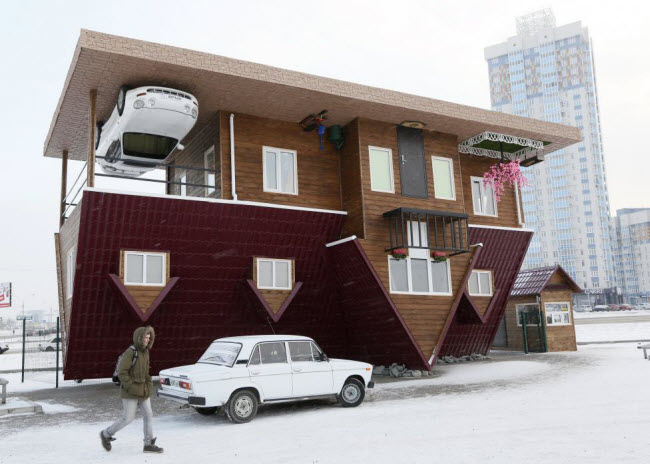 Người đàn ông đi qua ngôi nhà lộn ngược rất độc đáo ở thành phố Krasnoyarsk, Nga.