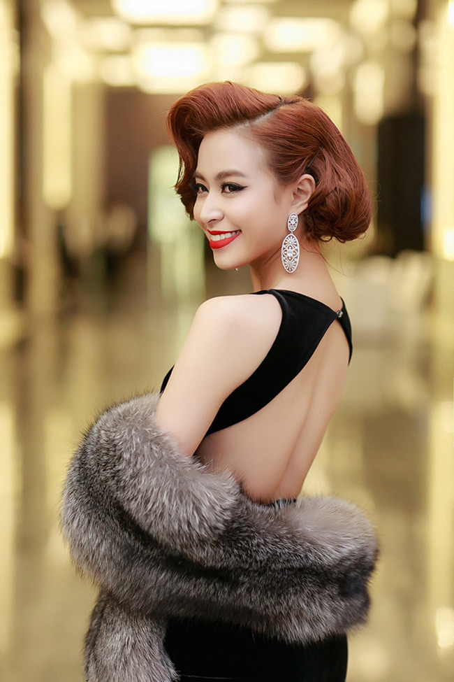 Tại một bữa tiệc xa hoa với phong cách cổ điển, nữ ca sĩ khoe vẻ sexy nhưng không kém phần sang trọng với váy đen trần lưng và áo choàng lông xám hững hờ. 