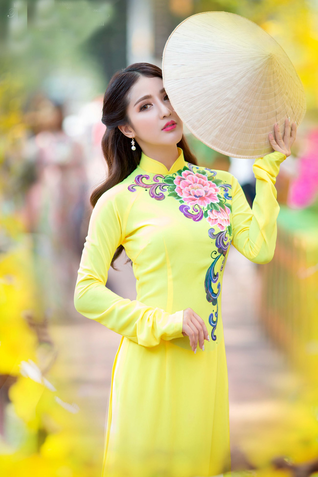 Trong một shoot hình khác, Linh Napie diện áo dài sắc vàng tươi với những họa tiết vẽ đầy sắc xuân.