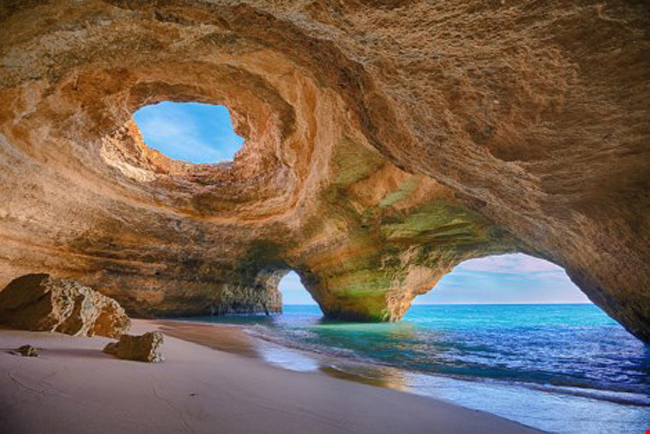 7. Hang Benagil, Algarve, Bồ Đào Nha:&nbsp;Du khách chỉ có thể vào đây bằng các loại tàu hay chèo thuyền kayak. Khi đã vào bên trong, bạn có thể thư giãn trên bãi cát mịn màng, nằm tắm nắng và ngắm mây trời qua hố sụt tự nhiên trên trần hang. Ảnh:&nbsp;Ourplnt
