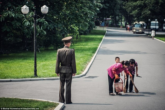 Một sĩ quan giám sát việc quét dọn vỉa hè tại một công viên ở thủ đô Bình Nhưỡng.