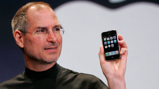 10 năm trước (ngày 9/1), cố CEO Steve Jobs huyền thoại của Apple đã trình làng chiếc iPhone đầu tiên tại sự kiện Macworld Conference & Expo ở Moscone West, San Francisco (Mỹ). Thiết bị sở hữu màn hình cảm ứng, có duy nhất nút Home là phím vật lý, và trang bị camera 2 megapixel.