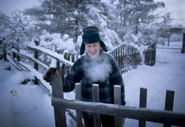 Một người dân bản địa đứng trước trang tại phủ đầy tuyết của mình tại ngôi làng Oymyakon.