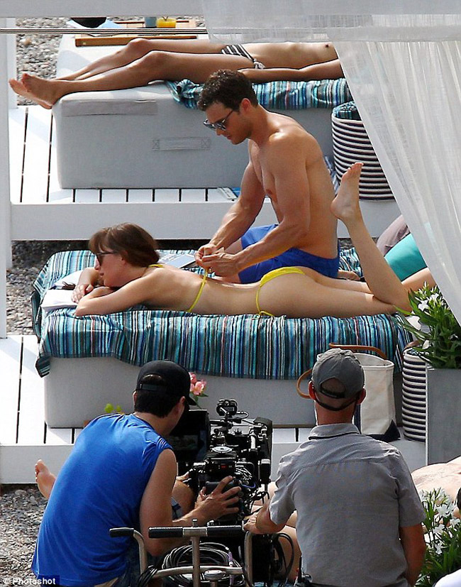 Cô còn có cảnh quay để lộ ngực trần và được bạn diễn Jamie Dornan (vai tỷ phú) buộc lại dây áo bikini.