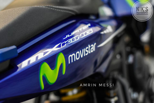 Tem xe màu xanh da trời đặc trưng, kết hợp logo Movistar kèm chữ M nổi bật.