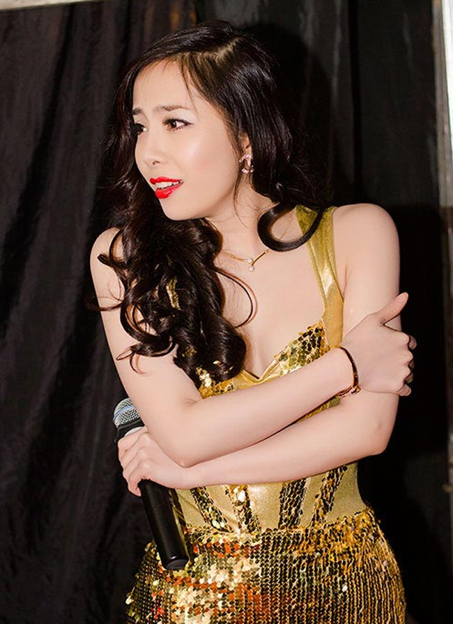 Nữ ca sỹ Quỳnh Nga co ro trong cánh gà để chờ tới phần biểu diễn của mình.