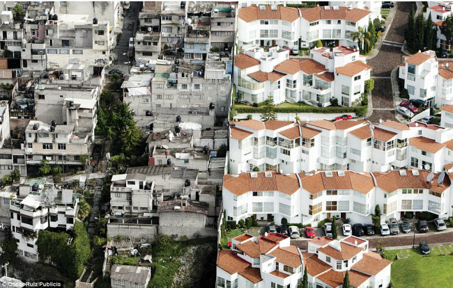 Tại Mexico, khu ổ chuột cũ nát (trái) bị ngăn cách với khu biệt thự dành cho những cư dân giàu có (phải) bằng một hàng rào cao.