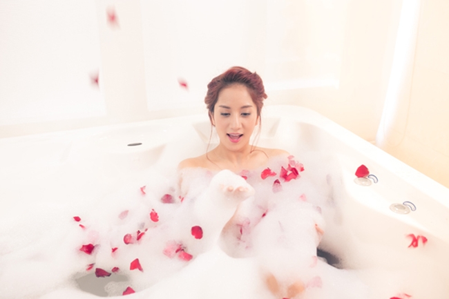 Khánh Thi từng gây xôn xao khi tự tin khoe hình thể gợi cảm trong MV "Ngày anh đến bên em". Trong MV, ca sĩ 34 tuổi có nhiều cảnh quay đẹp diện nội y trên giường và dưới bồn tắm rải đầy cánh hoa hồng.