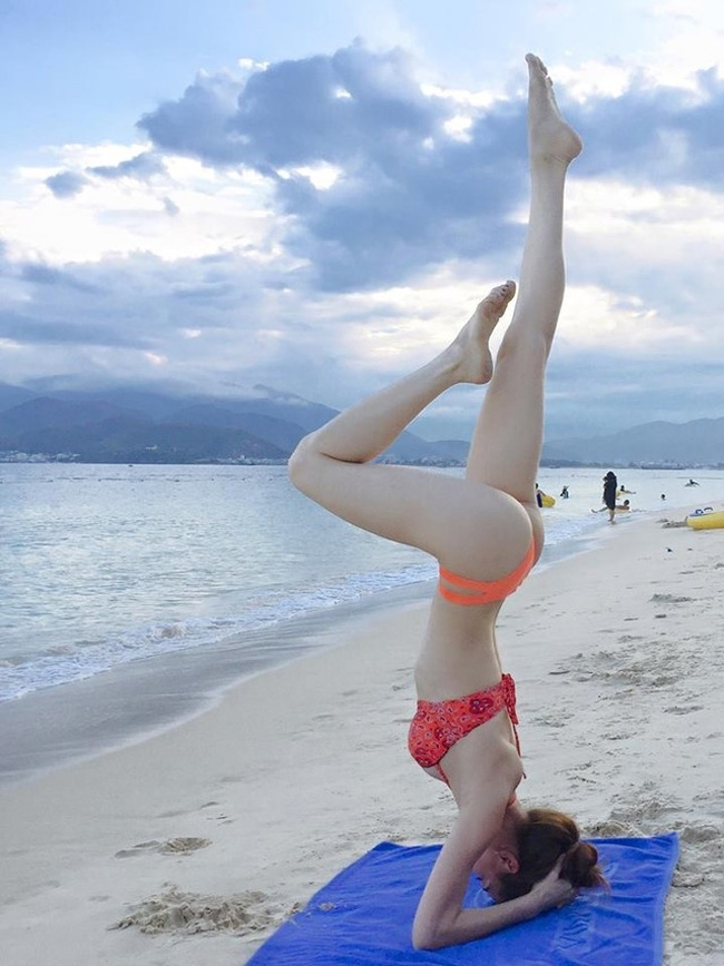 Cô khiến cả bãi biển phải "đứng hình" khi mặc bikini, trổ tài trồng cây chuối, tập yoga đầy điêu luyện.