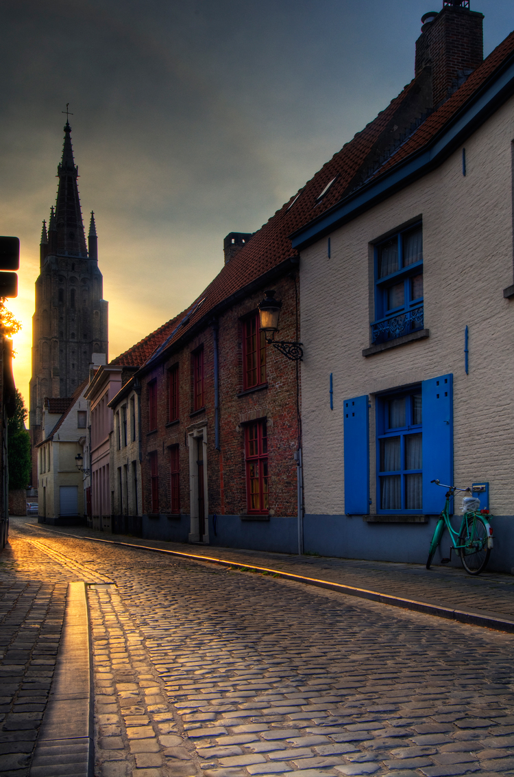 Một con đường cổ ở Bruges với tháp nhà thờ Our Lady thấp thoáng phía xa.