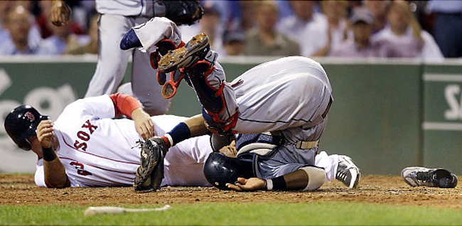 Carlos Santana của đội bóng chày Cleveland Indians cố gắng ngăn chặn Ryan Kalish của đội Red Sox ghi điểm. Kết quả của pha bóng dũng cảm này là Santana phải vào bệnh viện vì vỡ đầu gối.