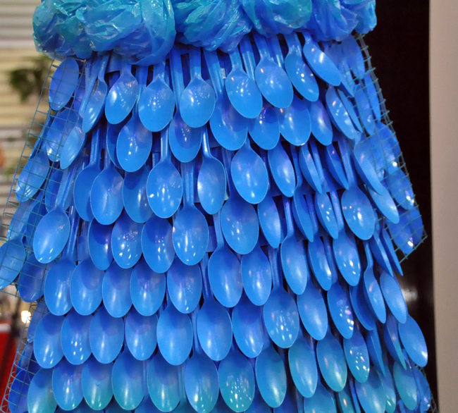 Toàn bộ váy được làm từ hàng trăm chiếc thìa nhựa màu xanh