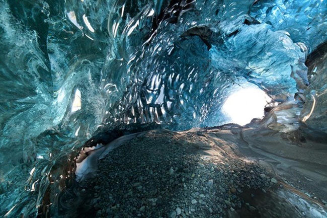 8. Hang động băng ở Skaftafell – Iceland.&nbsp;Đây là hang động nằm trong công viên quốc gia Skaftafell, nổi tiếng với vẻ đẹp kỳ ảo, lộng lẫy và tráng lệ của những khối pha lê bên trong. Phía trên trần hàng động là tập hợp gắn kết của vô số hạt khí bong bóng, khi được nước mưa gột rửa, các tia sáng chiếu trực tiếp xuống mặt đất sẽ tạo nên một loại ánh sáng xanh lung linh, lấp lánh khắp hang động.
