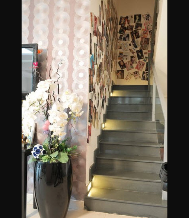 Trước lối đi lên cầu thang có bày một lọ hoa to, tạo cảm giác như có thiên nhiên trong nhà.
