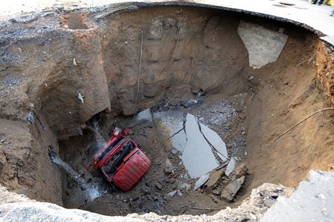 Một chiếc xe tải nằm dưới một hố tử thần xuất hiện vào ban đêm ở đường Shiliuzhuang, Bắc Kinh vào ngày 26.4.2011.