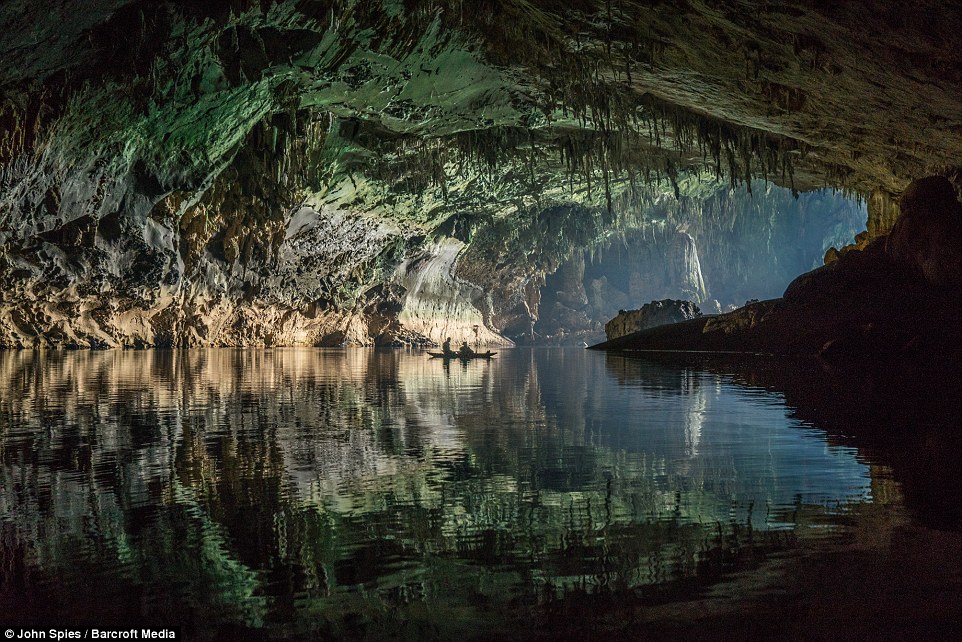 Hình ảnh mặt nước phản chiếu lấp lánh màu xanh ngọc lên vách đá từ cửa hang động.
