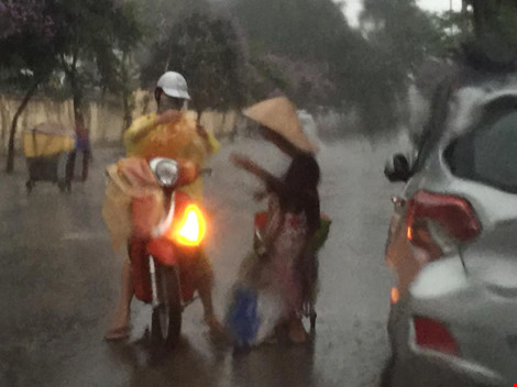 Cô gái dừng xe giữa trời mưa lớn mặc áo mưa cho cụ già - 1