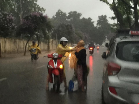 Cô gái dừng xe giữa trời mưa lớn mặc áo mưa cho cụ già - 3