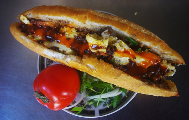 Bánh mì Hội An là một trong những có món bánh mì kẹp ngon khó cưỡng. Bánh mì ở đây vẫn có phần nhân cơ bản gồm pate, thịt nướng, chả lụa, rau thơm và nước sốt đặc biệt, điều làm nên sự hấp dẫn khác biệt của mỗi ổ bánh. Lớp vỏ giòn rụm, phần nhân béo bùi, không ngấy kết hợp với nhau khiến ai nấy đều thích thú.
