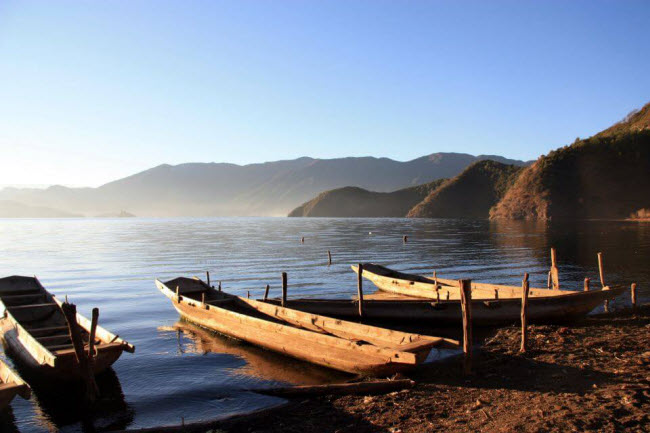 Những chiếc thuyền gỗ trên mặt nước rộng lớn của hồ Lugu, tạo nên khung cảnh rất yên bình và lãng mạn. Hồ nước này có diện tích 52 km, sâu 93m và nằm cách mặt nước biển 2.685 m.