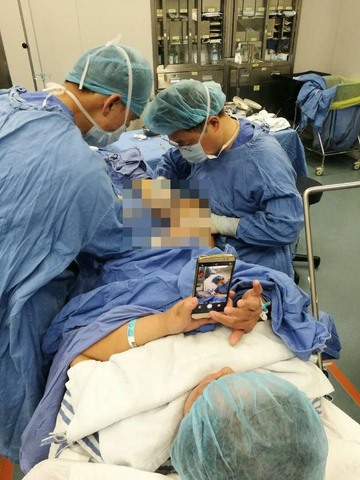 TQ: Bác sĩ mổ chân, bệnh nhân ung dung chơi điện thoại - 1