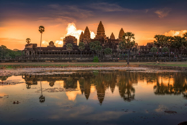 Ánh bình minh chiếu vào những áng mây trông như lửa cháy sau khu đền Angkor Wat ở Campuchia.