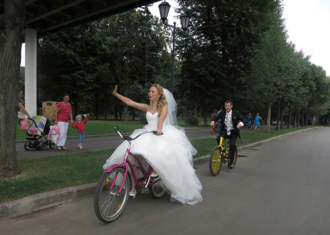 Một chú rể khác toát mồ hôi đạp xe theo cô dâu
