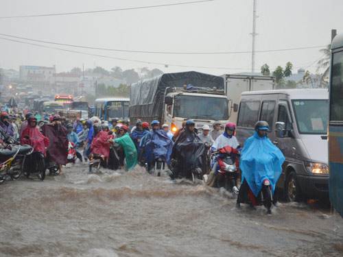 Nữ sinh đội mưa đẩy xe cho người đi đường - 1