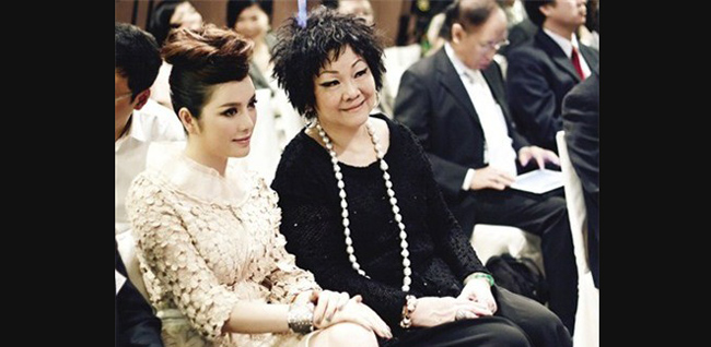 Cô tỏ ra sang trọng, quý phái khi ngồi cạnh mẹ nuôi là tỷ phú người  Hong Kong.
