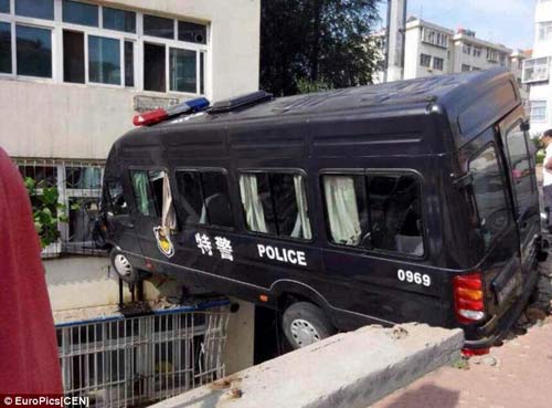 Trung Quốc: Xe cảnh sát treo lơ lửng giữa hai tòa nhà - 1