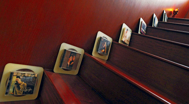 Cầu thang gỗ được trang trí khá lạ với những chiếc CD, album của Quang Dũng ở mỗi bậc.
