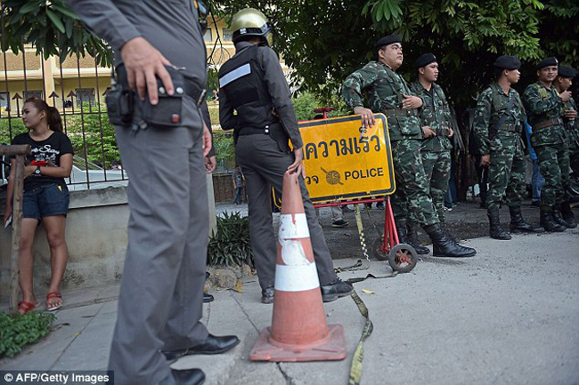 Lực lượng cảnh sát và quân đội đứng bảo vệ bên ngoài hiện trường bắt nghi phạm vụ đánh bom ở Bangkok.