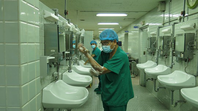 PGS Nguyễn Hữu Ước, Trưởng Khoa Tim mạch lồng ngực BV Việt Đức, rửa tay trước khi vào cuộc phẫu thuật lấy tạng từ người cho chết não tại BV Chợ Rẫy
