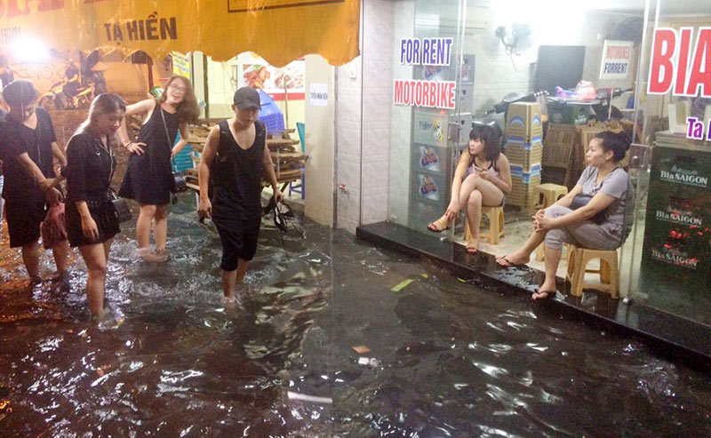 HN: Mưa xối xả, khách nước ngoài thích thú dạo trên... phố ngập - 2
