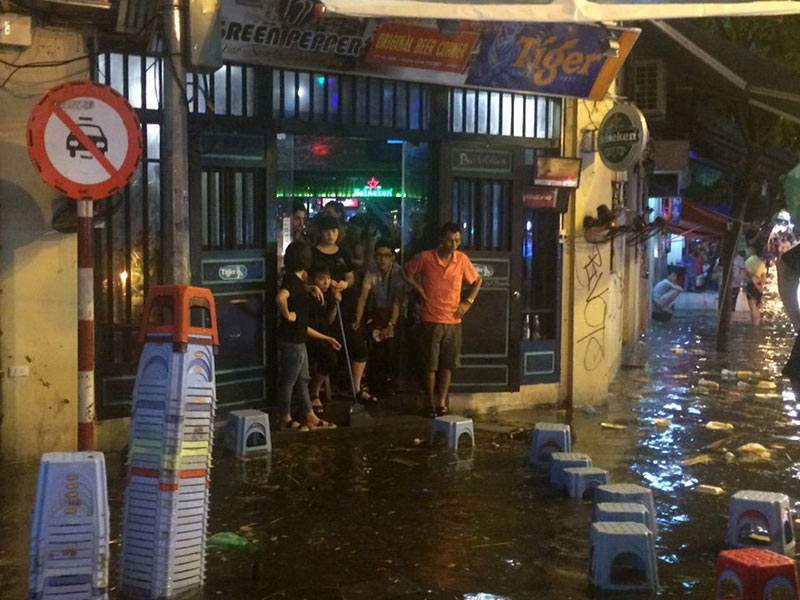 HN: Mưa xối xả, khách nước ngoài thích thú dạo trên... phố ngập - 4