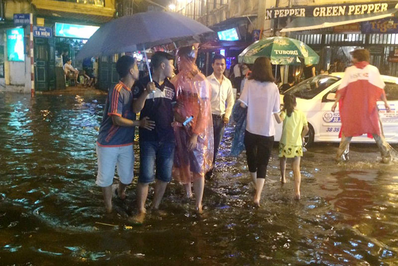 HN: Mưa xối xả, khách nước ngoài thích thú dạo trên... phố ngập - 5