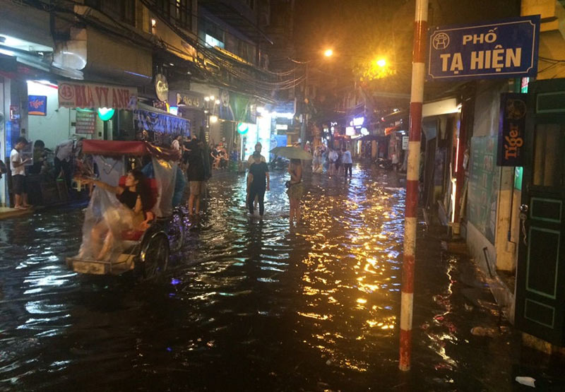 HN: Mưa xối xả, khách nước ngoài thích thú dạo trên... phố ngập - 6