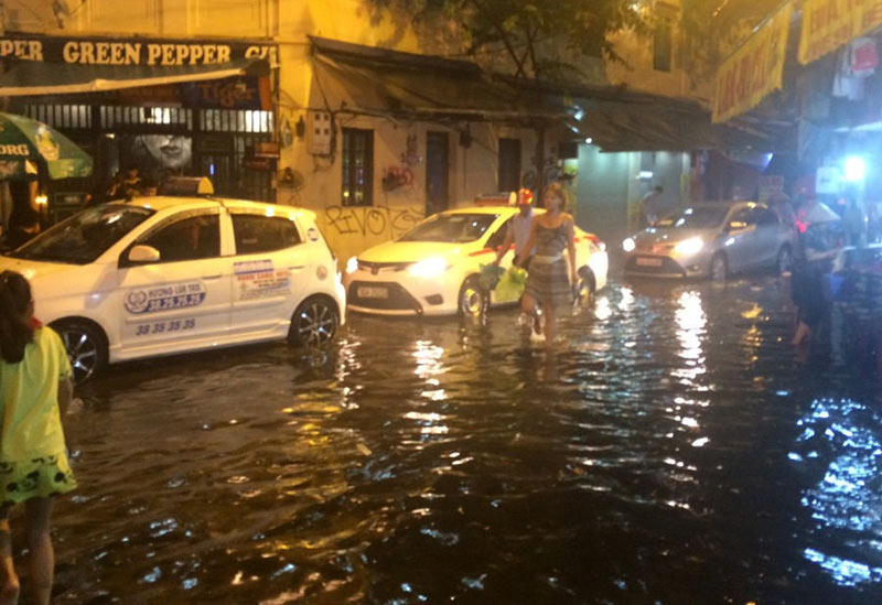 HN: Mưa xối xả, khách nước ngoài thích thú dạo trên... phố ngập - 7