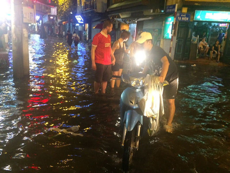 HN: Mưa xối xả, khách nước ngoài thích thú dạo trên... phố ngập - 8