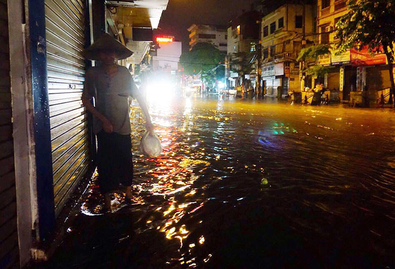 HN: Mưa xối xả, khách nước ngoài thích thú dạo trên... phố ngập - 12