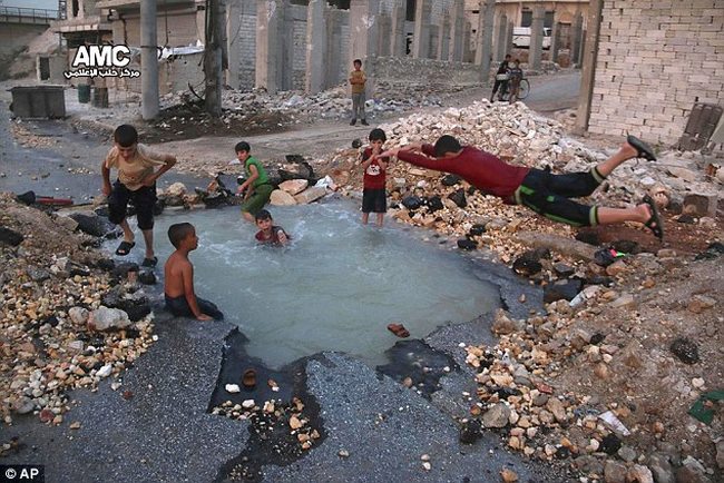 Trẻ em Syria biến hố bom thành hồ bơi giữa phố - 1