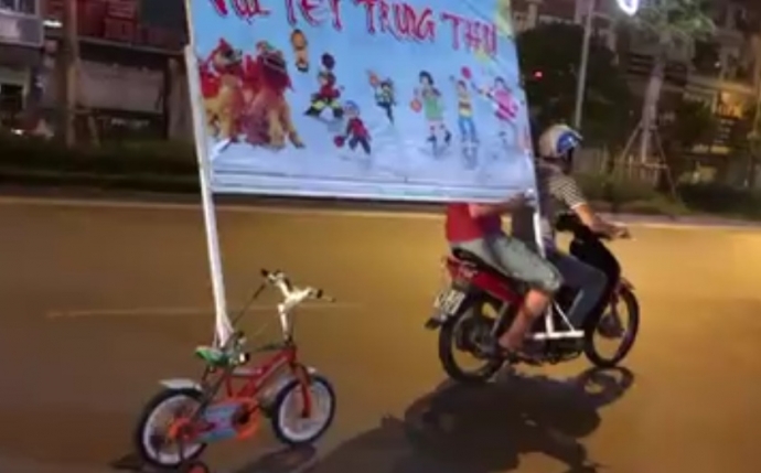 Pha chở biển quảng cáo bằng xe đạp 4 bánh náo loạn Hà Nội - 1